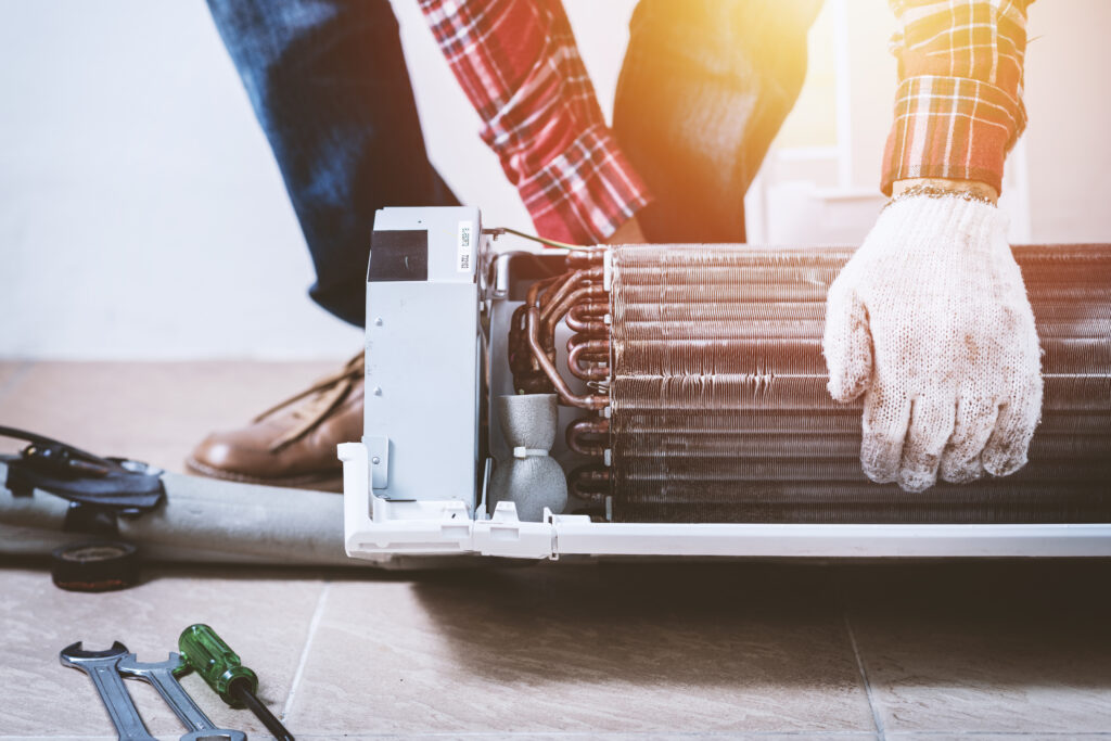 A technician setting evaporator coils next to tools to maintain the coils.